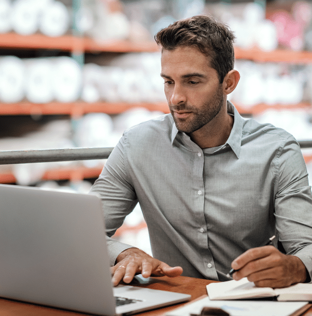 warehouse manager sitting at a desk using a laptop warehouse manager sitting at a desk using a laptop